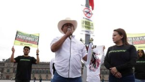 Activistas escalan asta bandera del Zócalo para exigir freno a planta de amoníaco en Topolobampo